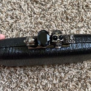Black clutch with skull/gem details.